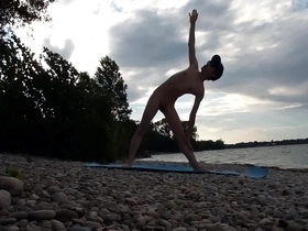 A slender Naturist boy does yoga at a beach full of Naturists.
