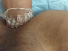A sissy in a solo scene, crossdressed and enjoying anal play with a fist.