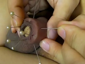 Japanese soloboy enjoys pain as his foreskin is pierced with a needle.